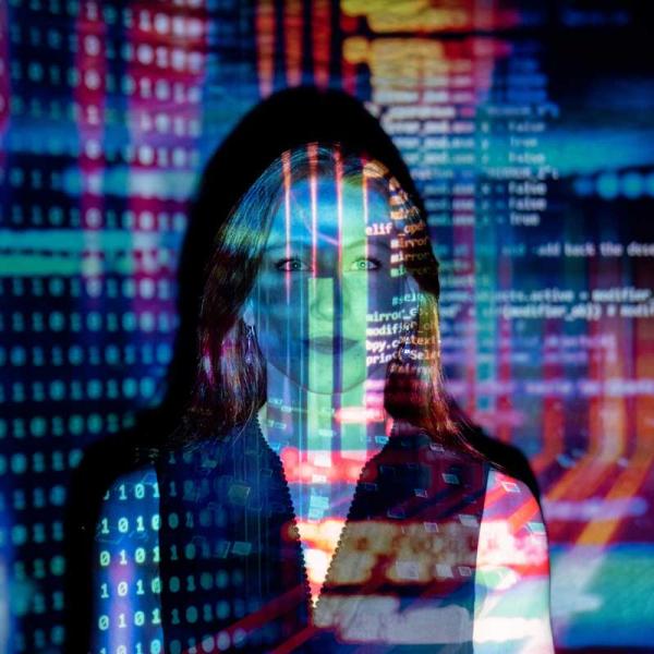 woman with colourful lines of computer code projected onto her face