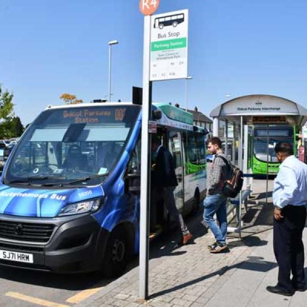 people getting onto an autonomous minibus at Didcot Parkway Station stop